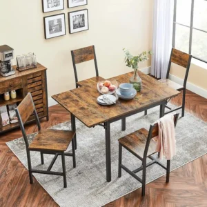 Comedor de estilo industrial con mesa plegable de madera rústica y estructura metálica negra, acompañado de cuatro sillas a juego, decorado con vajilla, un jarrón y un cuenco de frutas.