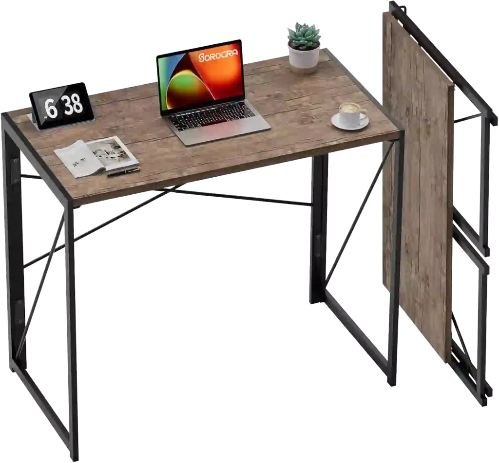 Mejor mesa plegable para escritorio con tablero de madera clara y estructura metálica negra, equipado con portátil, reloj digital, taza, planta decorativa y revista.
