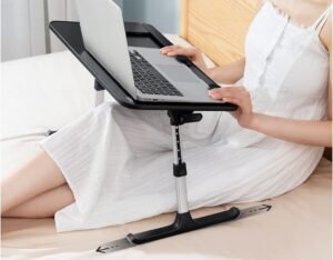 Mujer usando mesa para notebook sobre la cama con patas deslizables.
